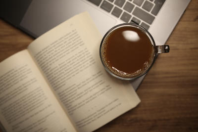 Photo of book with coffee and laptop